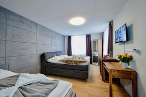 Hotel Giamas في شتراوبينج: غرفة نوم بسريرين وطاولة وتلفزيون