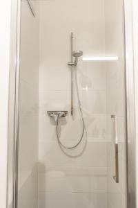 a shower with a hose in a bathroom at MyRoom - Top Munich Serviced Apartments in Munich