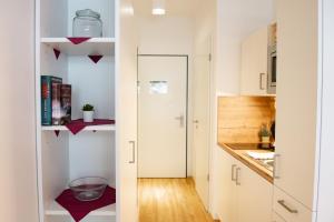 a small kitchen with white cabinets and a counter top at MyRoom - Top Munich Serviced Apartments in Munich