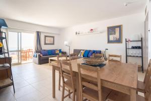 a dining room and living room with a table and chairs at KEY-WISE La Mar Salá Primera Linea de Playa con Parking incluido y Piscinas in Fuengirola