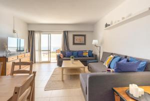 een woonkamer met een bank en een tafel bij KEY-WISE La Mar Salá Primera Linea de Playa con Parking incluido y Piscinas in Fuengirola