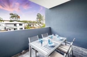 d'une table et de chaises blanches sur un balcon. dans l'établissement G3 Apartment, à Brisbane