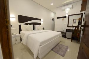a hotel room with a bed and a dresser at Diva Villa Airport Transit Hotel in Katunayake