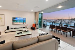 Pavillion 3 Absolute Waterfront 4 Bedroom 2 Lounge Room Plunge Pool + Golf Buggy في جزيرة هاميلتون: غرفة معيشة مع أريكة وطاولة