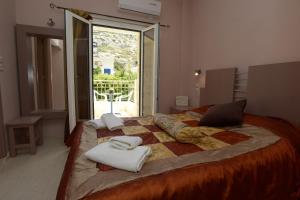a bedroom with a bed with towels and a window at Fantastic Matala 1 in Matala