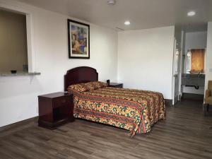 um quarto de hotel com uma cama e uma mesa de cabeceira em Welcome Inn Motel em Montclair