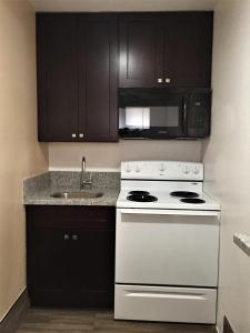 a kitchen with a white stove and a sink at Welcome Inn Motel in Montclair