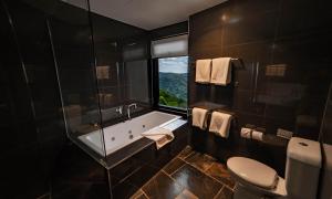 a bathroom with a toilet, sink and bathtub at Binna Burra Sky Lodges in Beechmont
