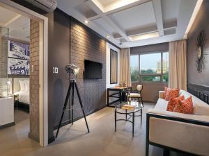 a living room with a couch and a tv at Summit Hotel Magnolia in Manila