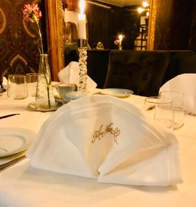una mesa con un plato blanco en una mesa en Palace Hotell, en Hultsfred