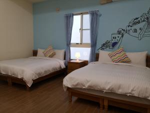 Posteľ alebo postele v izbe v ubytovaní Hengchun Inn