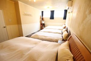 szereg łóżek w małym pokoju w obiekcie kODATEL コダテル 札幌大通公園 アネックス w mieście Sapporo