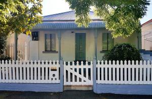 a white picket fence in front of a house at Blue and White Nile in Orange