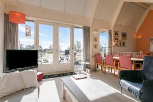 a living room with a television and a table with chairs at Quo Vadis in Grou