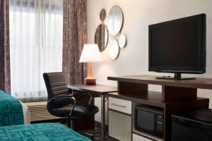 ein Hotelzimmer mit einem TV auf einem Schreibtisch mit einem Bett in der Unterkunft Howard Johnson by Wyndham Appleton in Appleton