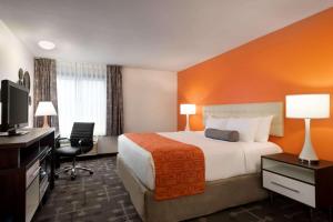 a hotel room with a bed and a flat screen tv at Howard Johnson by Wyndham Appleton in Appleton