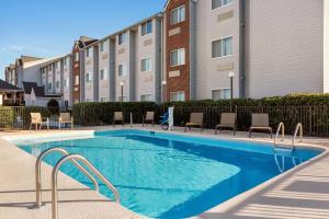 una piscina con sillas y un edificio en Microtel Inn & Suites by Wyndham, en Tifton