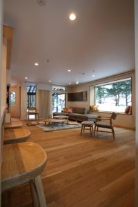 een grote woonkamer met een bank en tafels bij ASANOHA in Furano