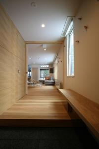 een hal met houten vloeren en een groot raam bij ASANOHA in Furano