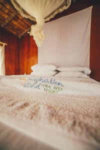 a close up of a white bed with a sign on it at Imagination Island in Gizo