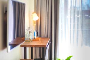 a room with a table with a lamp and a window at Celosia Chiang Mai Hotel in Chiang Mai