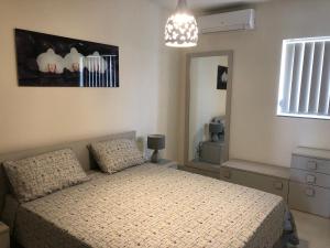 Schlafzimmer mit einem Bett und einem Spiegel in der Unterkunft Marsascala Sea View Apartment HPI 7738 in Marsaskala