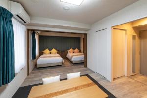 a hotel room with two beds and a table at SARASA HOTEL Dotonbori in Osaka