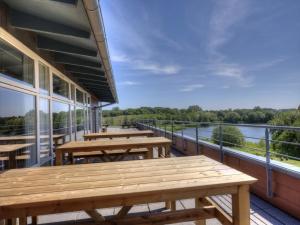 balcón con mesas de madera y vistas al agua en Danhostel Fredericia, en Fredericia