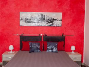 a red bedroom with a bed with red walls at Bouganville House in Zafferana Etnea