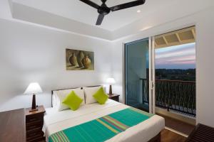 尼拉瓦利的住宿－CASAMIA Oceanfront Condos Nilaveli，一间卧室设有一张床和一个阳台