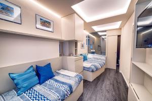 2 bedden met blauwe kussens in een kamer bij La Casetta di Portofino by PortofinoVip in Portofino