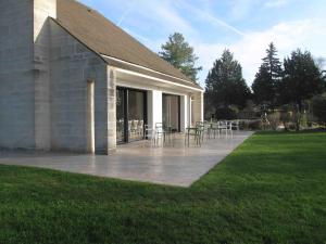 a patio with chairs and tables outside of a building at Clos La Chapelle in Mareuil-sur-Ay