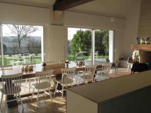 comedor con mesa, sillas y ventanas en Clos La Chapelle en Mareuil-sur-Ay