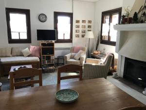 a living room with a table and a fireplace at Aegean Sunset in Damouchari