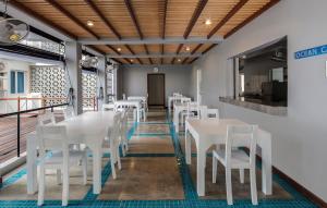 a dining room with white tables and white chairs at CASAMIA Oceanfront Condos Nilaveli in Nilaveli