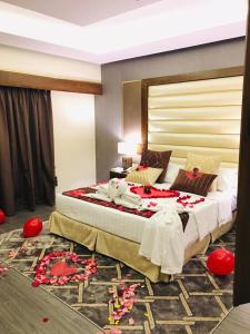 a bedroom with a large bed with red flowers on the floor at Ramada by Wyndham Dammam Khaleej Road in Dammam