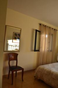 1 dormitorio con silla, espejo y cama en Tramuntana & Beach, en Pollensa