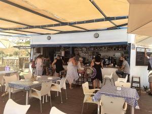 a group of people in a restaurant with tables and chairs at Manilva Playa in Manilva