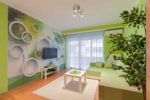 a living room with green walls and a green couch at AquaFlat in Budapest