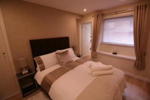 a bedroom with a large bed and a window at The Thomas Suite in Llandudno