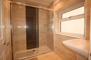 a bathroom with a shower and a sink at The Thomas Suite in Llandudno