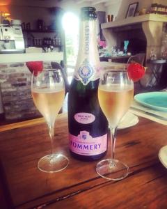 - une bouteille de champagne et deux verres sur une table dans l'établissement villa les champs de knokke, à Knokke-Heist