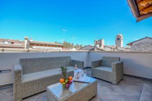 a balcony with two chairs and a table with fruit on it at Luxury Suite Sirmione in Sirmione