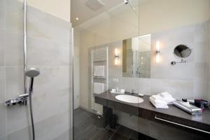 W łazience znajduje się umywalka i lustro. w obiekcie Hotel Villa Sanct Peter w mieście Bad Neuenahr-Ahrweiler