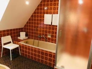 a bathroom with a tub and a chair in it at Schrapper in Grönheim