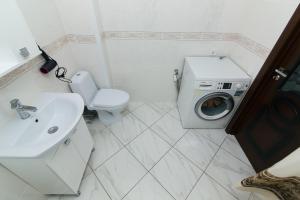 een badkamer met een wastafel en een wasmachine bij 16 вулиця Прокоф'єва in Sumy