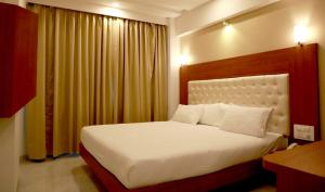 sypialnia z dużym białym łóżkiem i oknem w obiekcie Hotel Lords, Fort w Bombaju
