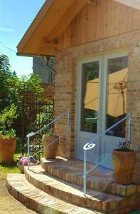 a front door of a house with stairs and an umbrella at Landhaus Sinneswandel in Nauen