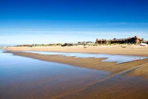 a view of a beach with a house in the background at Puerto Antilla Grand Hotel in Islantilla