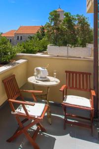 um pátio com 2 cadeiras e uma mesa na varanda em Hotel Spongiola em Krapanj